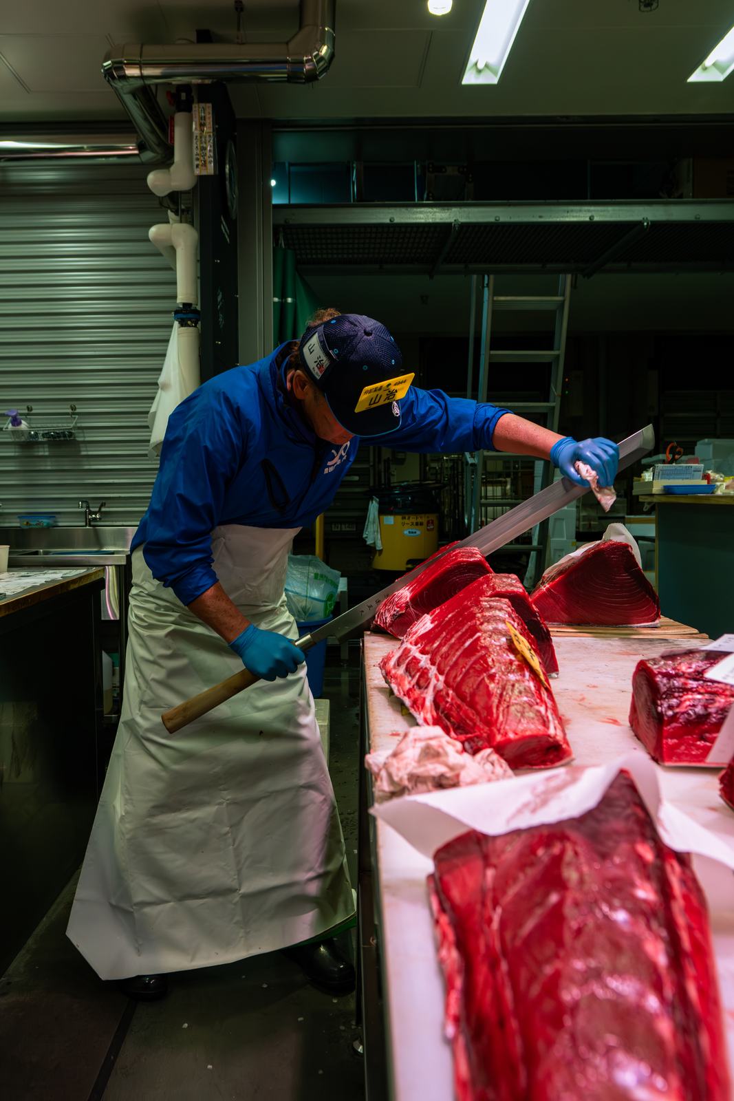 A tuna wholesaler at Toyosu cutting a bluefin loin