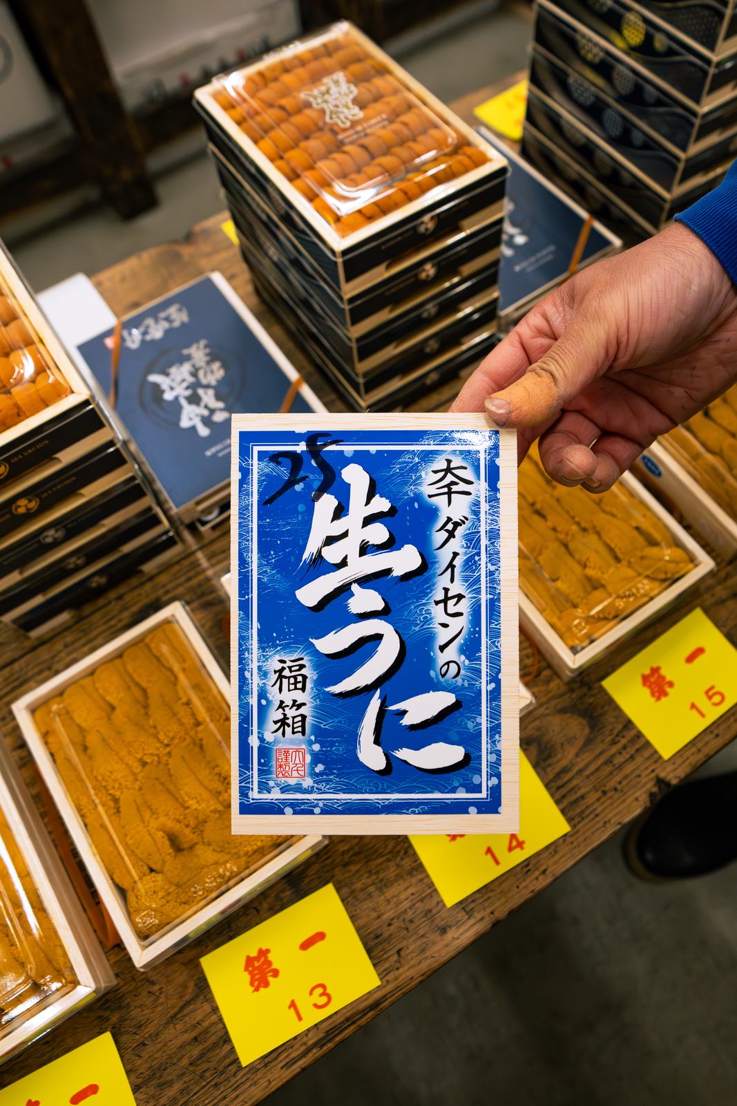 A Nemuro uni lot card held over trays at the morning auction